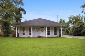 A single-story house with a gabled roof, a front porch, and a front yard.