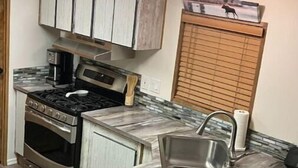 A kitchen with a stove, oven, sink, and cabinets. - Fun Rustic 2/2 Single level in a great community. (Laughlin)