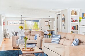 A modern living room with a beige sofa, a coffee table, and a bookshelf.