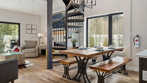 Una cocina moderna con una mesa de comedor de madera, bancos y una escalera en espiral.