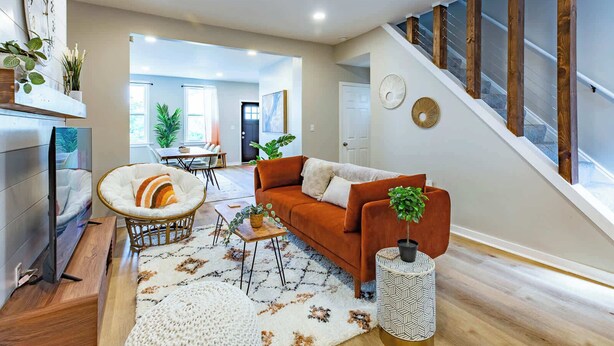A modern living room with a sofa, coffee table, and decorative plants.