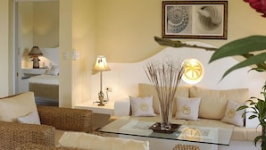A living room with a sofa, a glass coffee table, a lamp, and a wall-mounted picture frame. -  Dream Holidays Vacation (Puerto Plata)