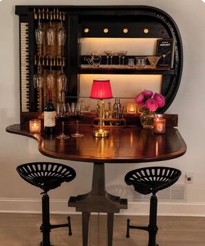 A bar area with a piano, wine glasses, a red lamp, and pink flowers. - Romantic Retreat, Hot Tub, Firepit (Syracuse)