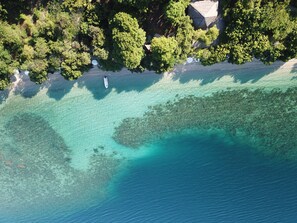 Privat strand, hvit sand, solsenger og parasoller