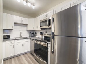 Fridge, microwave, coffee/tea maker, cookware/dishes/utensils