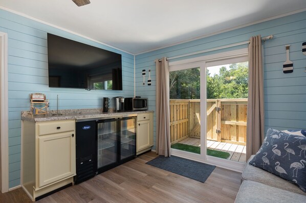 A compact kitchen with a dishwasher, microwave, and a flat-screen TV. - Just Wright: Heated Pool, Soundside, close to beach & sound! (Kitty Hawk)