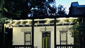 A house with a porch, a green door, and string lights. - UP ON MAIN - a charming historic apartment in the heart of Eureka Springs (Eureka Springs)