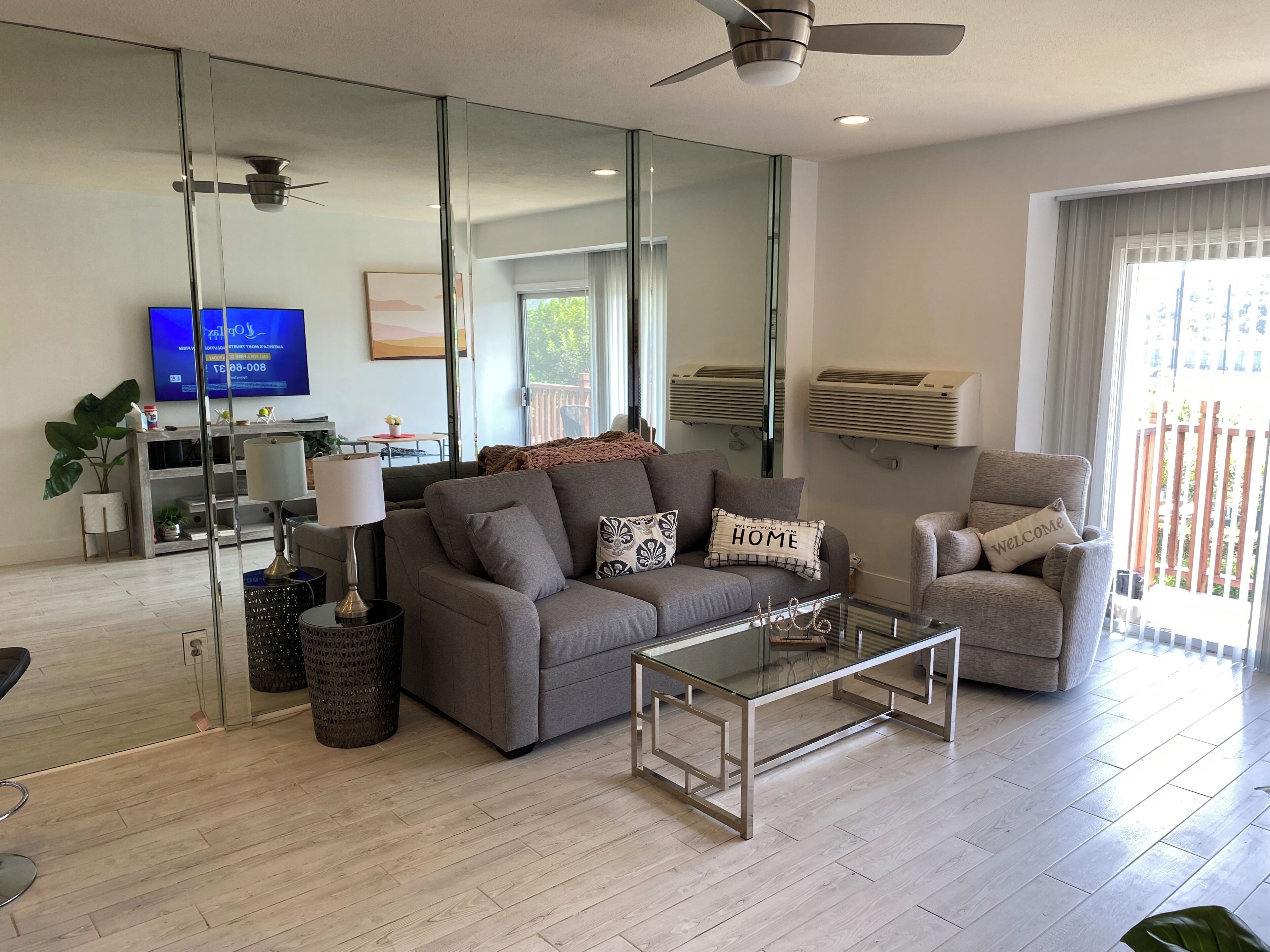 Una sala de estar moderna con un sofá, un sillón, una mesa de centro y un televisor.
