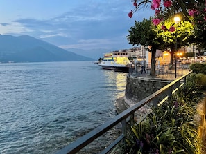 Eine Uferpromenade mit vertäutem Boot, Steinmauern und einem Geländer.
