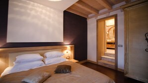 Une chambre à coucher avec un grand lit, une tête de lit en bois et une table de chevet avec une lampe.