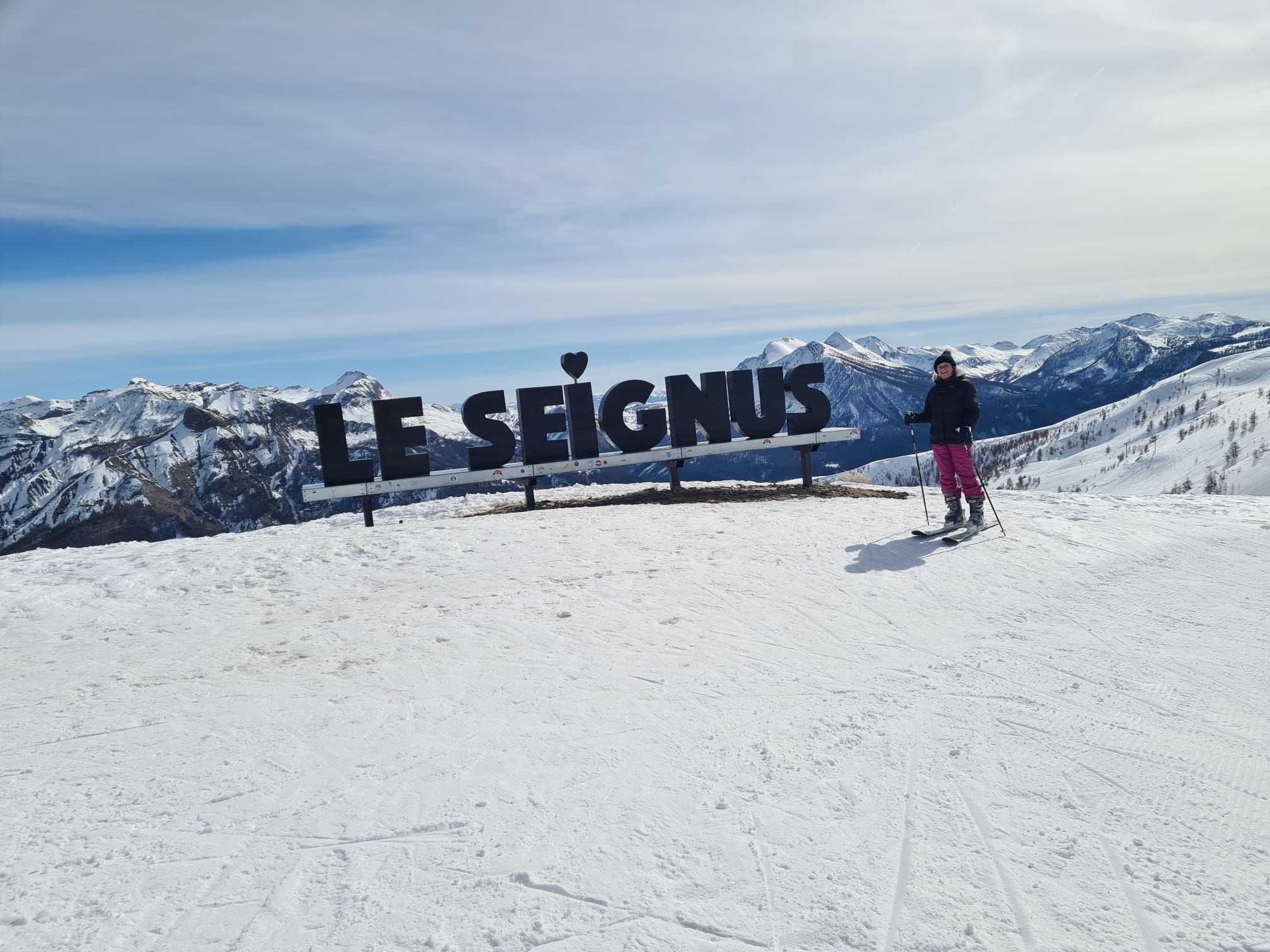 A sign with the text 'LE SEIGNUS' on a snowy mountain slope.