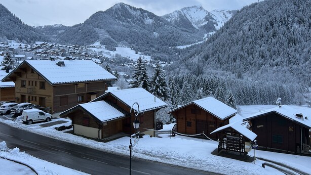 A snow-covered mountain village with wooden houses and a road. - Individual cottage 10-12 person  (Châtel)