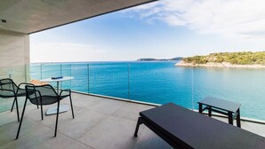 A balcony with a view of the sea, a table, and two chairs. - PureLuxuryExclusiveVillaStateOfTheArtVillaExcellentLocationPrivateBeach (Zaton)