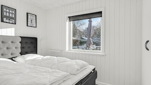 A bedroom with a bed, a window with a view of a snowy landscape, and two framed pictures on the wall. - 3 bedroom amazing home in Storvorde (Storvorde)