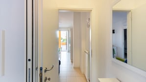 A hallway with a white door, a radiator, and a mirror on the wall. - Bright and comfortable apartment, able to accommodate up to 4 people, with a large double bedroom and bedroom with a bunk bed, equipped terrace, living room and kitchenette. Ideal for a relaxing beach holiday, a few meters from the Blue Beach and in a co (Marotta)