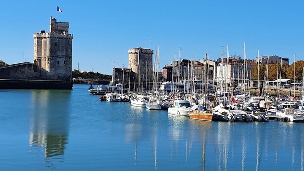 A marina with multiple boats docked, a prominent tower, and a clear blue sky. - 🌊 5 mn plage 🌴 Proche LA ROCHELLE - Charmant T2 🏡 4 Pers. (Salles sur Mer)
