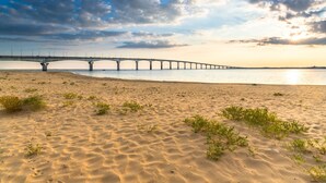 A beach with a long bridge in the background. - 🌊 5 mn plage 🌴 Proche LA ROCHELLE - Charmant T2 🏡 4 Pers. (Salles sur Mer)