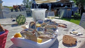 A table with oysters, a bottle, and a glass of white wine. - 🌊 5 mn plage 🌴 Proche LA ROCHELLE - Charmant T2 🏡 4 Pers. (Salles sur Mer)