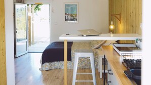 Eine moderne Küche mit einer Holz Arbeitsplatte, einem weißen Hocker und einer Pendelleuchte.