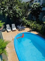 Una piscina con dos sillas de descanso y una escalera.