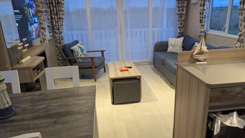 Una sala de estar moderna con sofá, sillón y mesa de centro.
