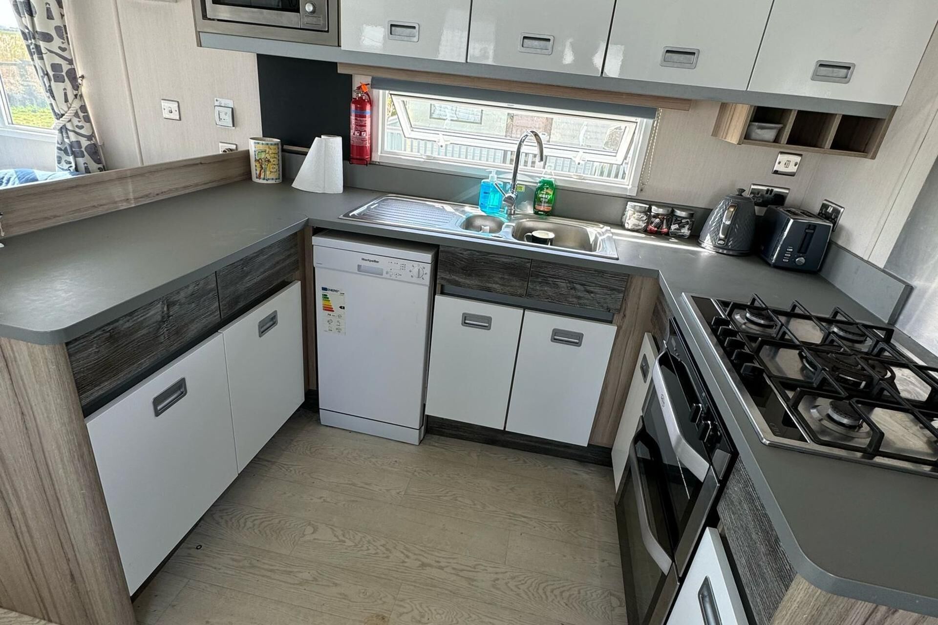 A compact kitchen with a dishwasher, a gas stove, and a sink.
