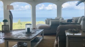 A room with a large window overlooking a scenic view, a wooden table, a sofa, and a lamp. - 400 m2 dream villa / 180 degree panoramic sea view, in top location!  (Dénia)