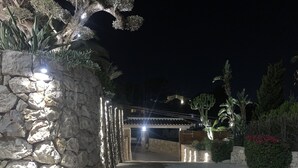 A stone pathway leading to a building with a tiled roof, surrounded by cacti and flowering plants. - 400 m2 dream villa / 180 degree panoramic sea view, in top location!  (Dénia)