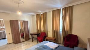 Ein modernes Schlafzimmer mit einem großen Bett, einem Holzschrank, einem kleinen Tisch und einem Stuhl.