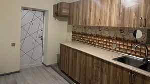 Eine Küche mit Holzausbau, einer gefliesten Spritzschutzleiste und einem Spülbecken.