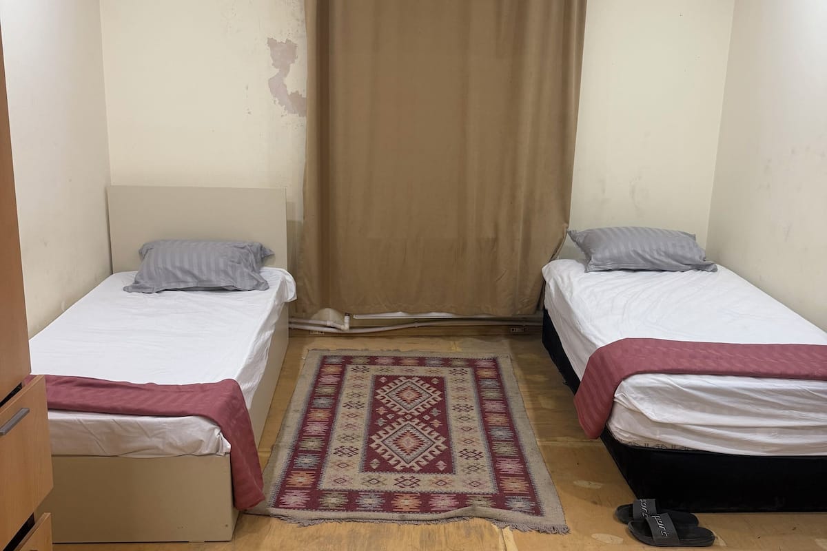 Habitación básica con 1 cama matrimonial o 2 individuales | Espacio para trabajar con laptop y tabla de planchar con plancha