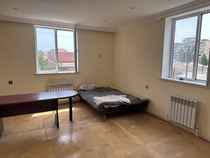 Habitación económica, cocina básica, en la zona del jardín | Espacio para trabajar con un portátil y tabla de planchar con plancha