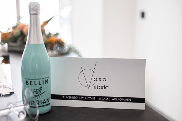 A bottle of Bellini cocktail and a business card with the name 'Vasa Vittoria' and the word 'BENVENUTO' on it. - Casa Vittoria, a charming vacation home just 5 minutes from the beach. (Monopoli)