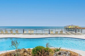 A pool area with lounge chairs and a view of the ocean. - Top Floor Oceanfront Condo w/ Pool & Beach Access! (Daytona Beach Shores)