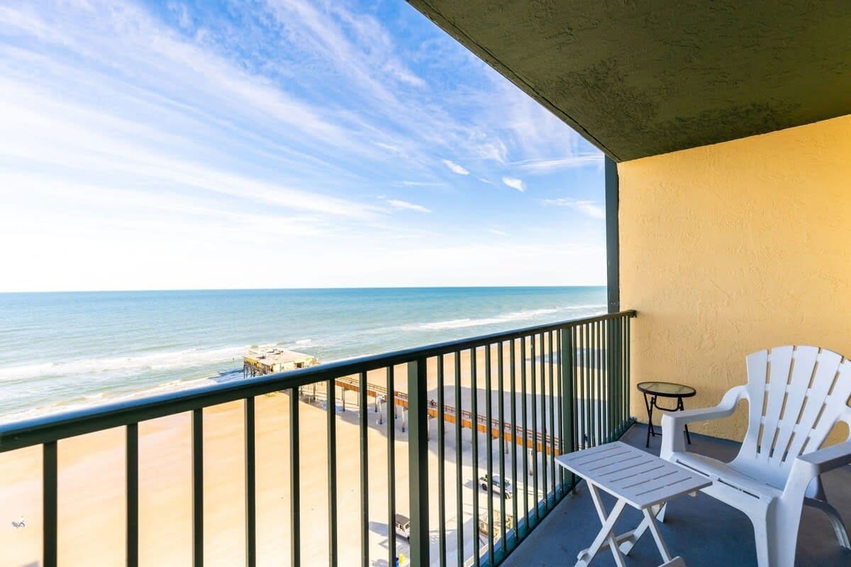 A balcony with a view of the beach and ocean.