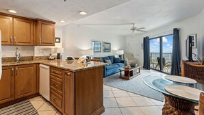 A spacious living area with a kitchen, a dining area, and a balcony with a view. - Ocean View Suite w/ Pool, Hot Tub & Beach Access (Daytona Beach Shores)