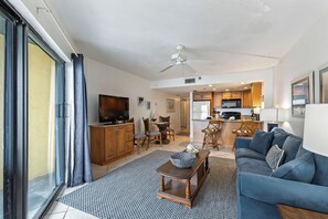 A modern living room with a sofa, TV, and dining area. - Ocean View Suite w/ Pool, Hot Tub & Beach Access (Daytona Beach Shores)