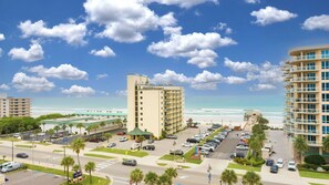 A beachfront hotel with multiple floors, a parking lot, and a view of the ocean. - Ocean View Suite w/ Pool, Hot Tub & Beach Access (Daytona Beach Shores)