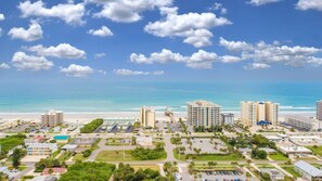 Un paisaje urbano costero con hoteles frente a la playa, cielo despejado y vista al océano.