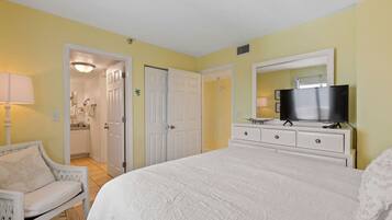A bedroom with a bed, a television, a dresser, and a chair.