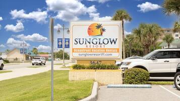 Placa do Sunglow Resort anunciando aluguel de imóveis à beira-mar.