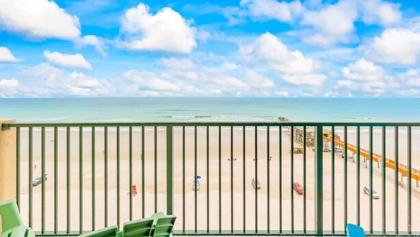 Un balcón con vista a una playa y un muelle.