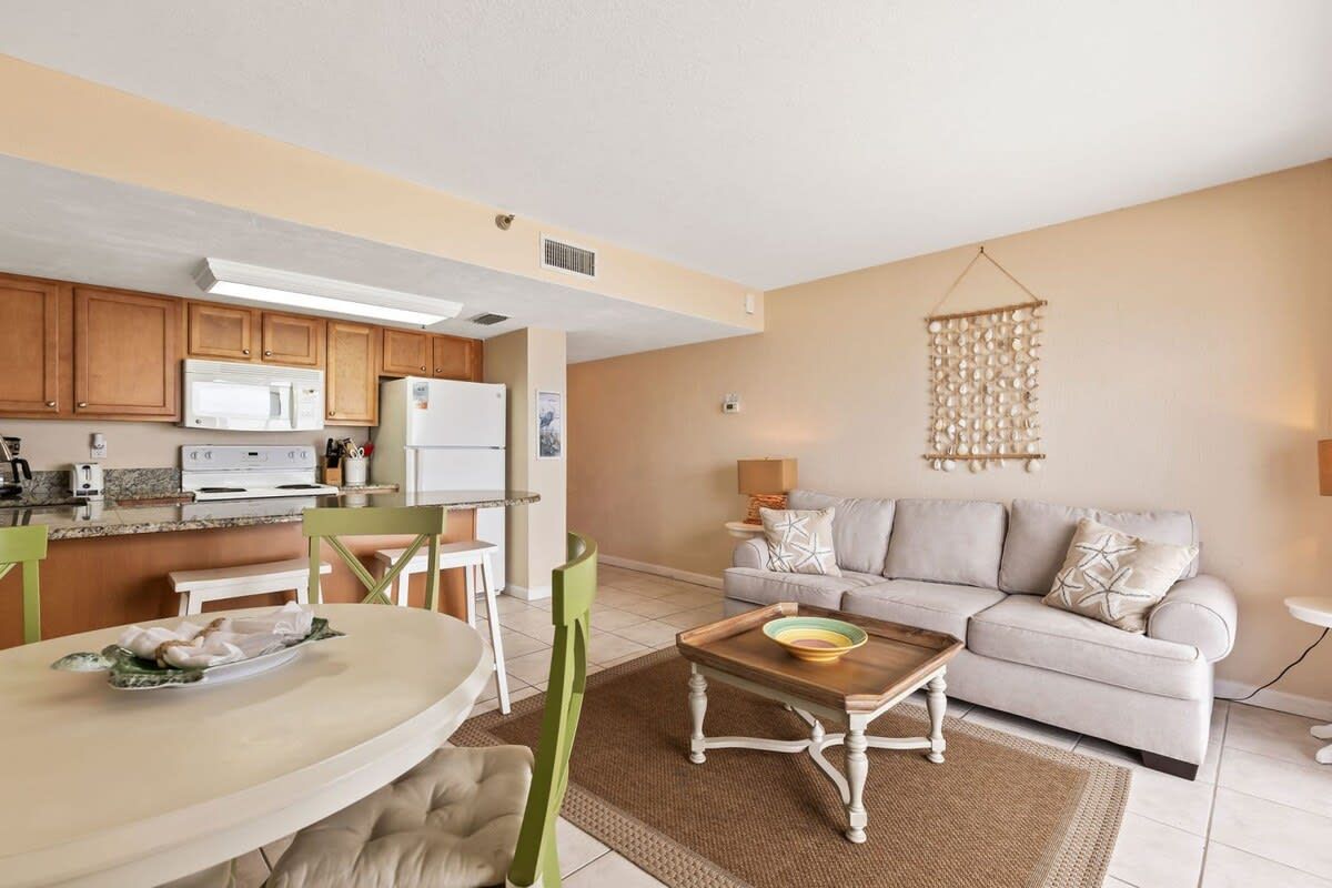 A compact living space with a kitchenette, a dining area, and a seating area with a sofa and a coffee table.