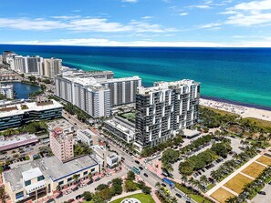 A high-rise hotel with multiple floors, a central courtyard, and a view of the ocean. - Private Home Hotel W South Beach By LMC (Miami Beach)