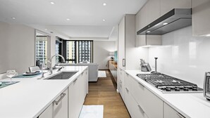 Una cocina moderna con armarios blancos, una isla central y una estufa integrada.