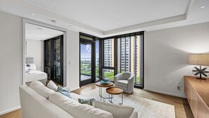 Una sala de estar moderna con un sofá, una silla, una mesita y una lámpara.