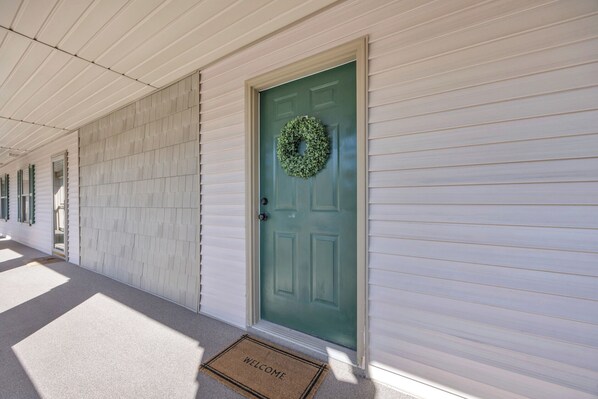 A house with a green door, a welcome mat, and a patterned wall. - TB 54P Beautiful updated 2 Bedroom True Blue condo with golf course views (Pawleys Island)