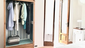 A room with a wooden wardrobe, a bed, and a small bedside table with a lamp. - Central Private home,  close to all you need in Viareggio (Viareggio)