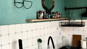 A kitchen with a sink, a toaster, a coffee maker, a mirror, and shelves with jars and glasses. - Central Private home,  close to all you need in Viareggio (Viareggio)