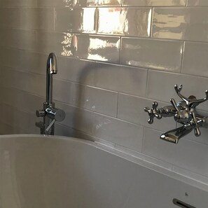 A bathroom with a bathtub, a handheld showerhead, and a wall-mounted faucet. - Central Private home,  close to all you need in Viareggio (Viareggio)